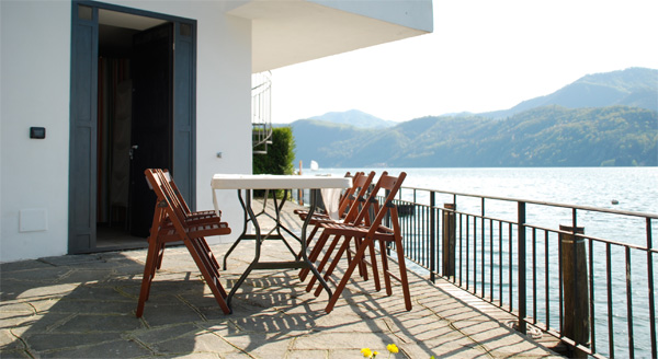 Dining table in lake-side paved area, in front of the door to the summer kitchen