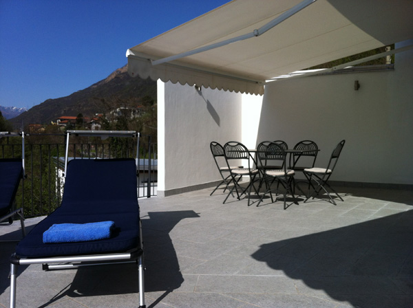 Sunbeds and outside dining table of 3rd floor balcony of Villa Heureka