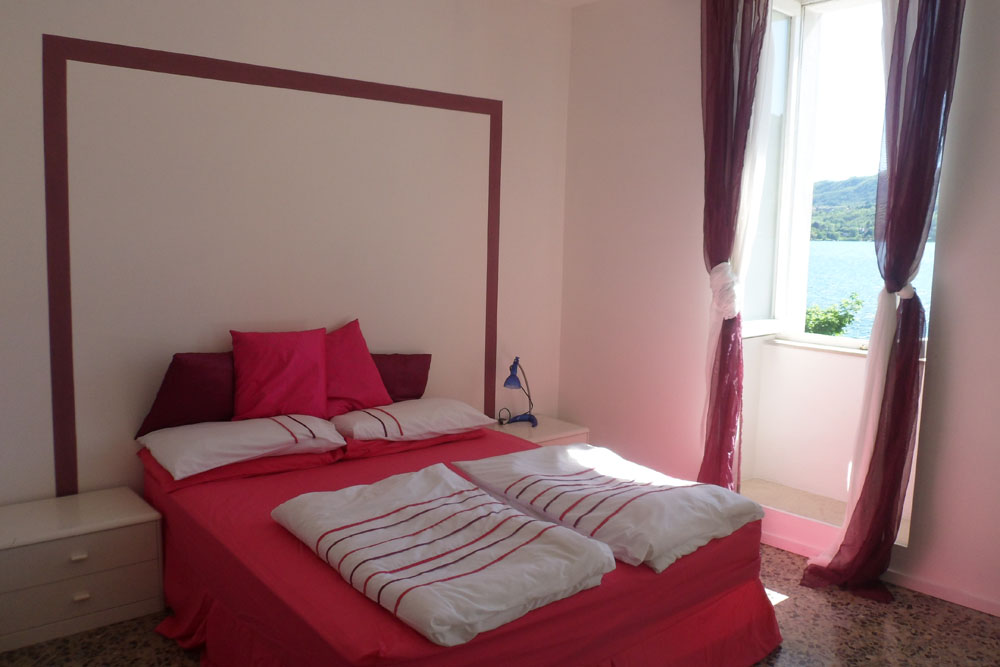Newly refurbished bedroom area of apartment 'Isola', with superb view of Piazza Motta and the island of San Giulio